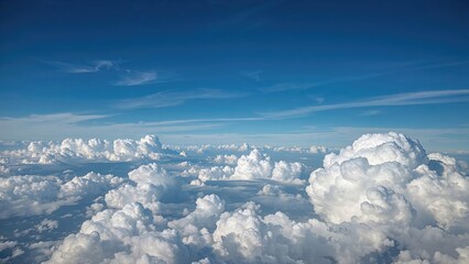 Aerial view of clouds over the sky with blue and white hues. Clear sky and fluffy clouds, high altitude perspective. © Lasvu