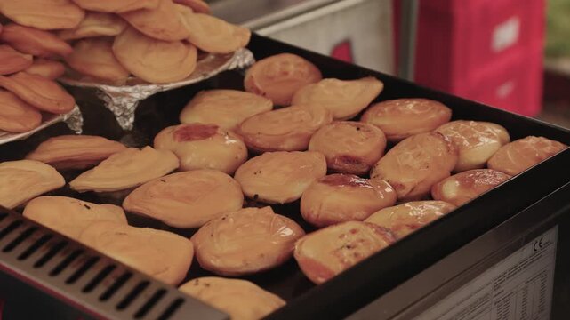 Close-up of traditional smoked cheese, Oscypek, grilling on a hot plate. This appetizing scene evokes a Polish street food market. Ideal for travel, culture, and culinary content.