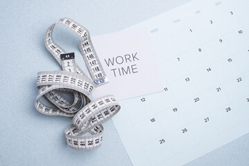 Fitness progress tracking: measuring tape, "Work Time" note, and calendar for health and body goals