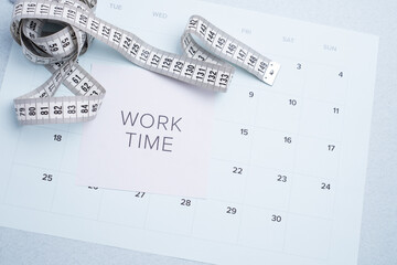 Fitness progress tracking: measuring tape, "Work Time" note, and calendar for health and body goals