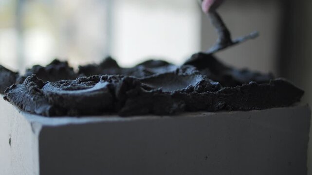 Applying mortar on aerated concrete block with trowel