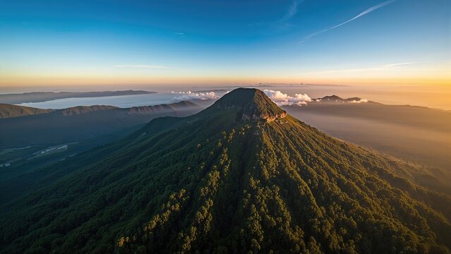 Mountain landscape during sunrise or sunset with lush green slopes and distant hills. Nature scenery and scenic view of the mountain range at dawn or dusk.