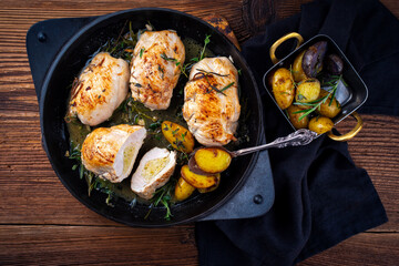 Traditional fried chicken breast fillet stuffed with egg pistachio souffle served as top view in a frying pan