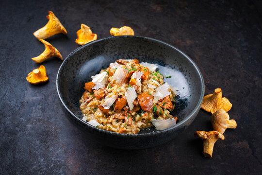 Traditional Italian risotto con finferli with fresh chanterelles and rparmesan served as close-up in a Nordic design bowl