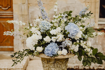 Bouquet d'hortensias bleus et de roses blanches pour fleurir le mariage 