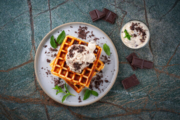 Fresh baked homemade belgian  Brussels waffles with mascarpone cream fresh and dark chocolate topping served as top view on a design plate