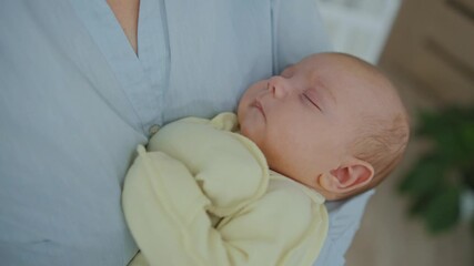 A mother cradles her infant in her arms close up. Concept of late motherhood