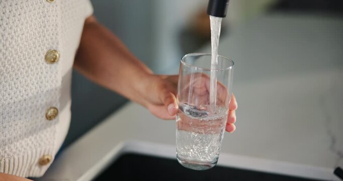 Glass, water and tap with hands of woman in kitchen of home for detox drinks, mineral hydration and health. Electrolytes, wellness and aqua with person and faucet in apartment for liquid and beverage