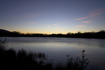 Wide Dusk View of Calm Lake Water and Vast Sky with Sunset Gradient