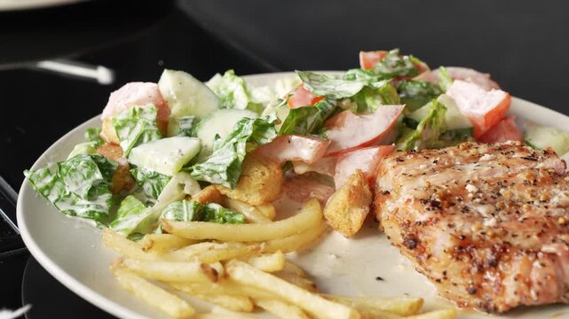 Pork grilled stake served with french fries and vegetable salad on white plate