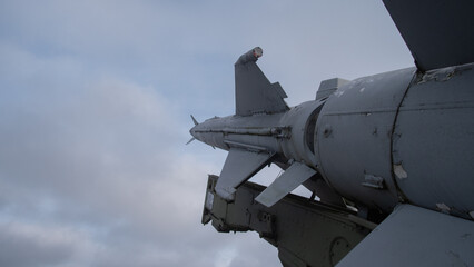 military aircraft weaponry showcasing missile deployment system against cloudy sky backdrop