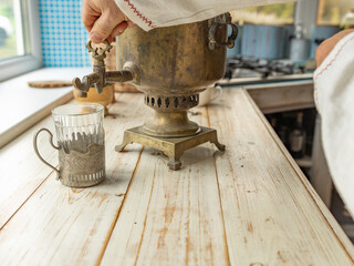 Person is pouring water into a brass tea kettle