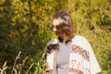 Woman enjoying nature in a sunlit forest, surrounded by green plants and soft shadows