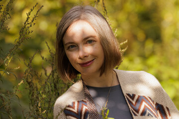 Gentle sunlight illuminates a woman in a natural setting surrounded by greenery and warm autumn colors