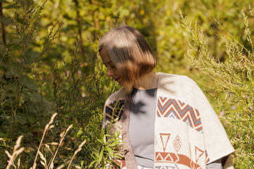 Woman exploring nature in a sunlit green field during autumn's embrace