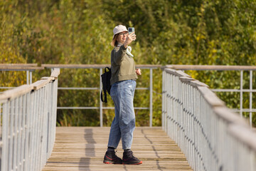 Capturing a joyful moment on a serene boardwalk surrounded by nature in bright daylight