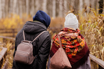 Couple exploring a serene path through autumn woods on a cool day