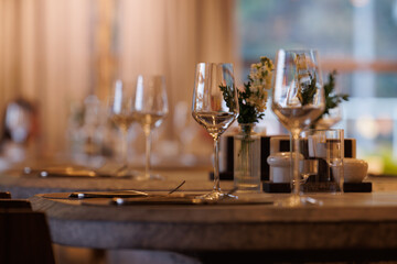 Elegant dining setting with wine glasses and flowers near a window in a cozy restaurant