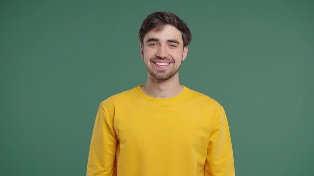 Cheerful Man Nods In Agreement, Approving With Yes Gesture On Green Background
