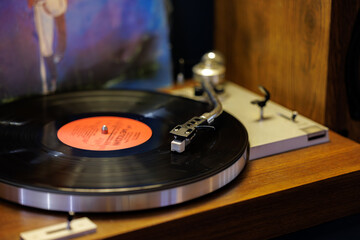 Vinyl records spin on a wooden turntable, creating a nostalgic atmosphere in a cozy room