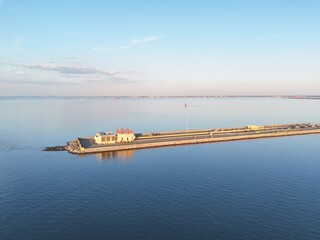 Aerial View Of Long Monitor Merrimac Memorial Bridge Tunnel crossing tranquil blue water of Hampton Roads Channel with a distant harbor and open sky