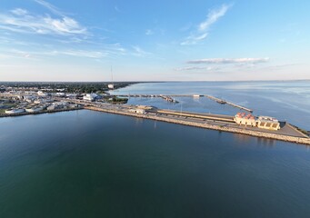 Aerial View Of Long Monitor Merrimac Memorial Bridge Tunnel crossing tranquil blue water of Hampton Roads Channel with a distant harbor and open sky