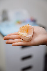 Obraz premium Transparent implant surgical guide on dental jaw model in clinician hand, clinic closeup