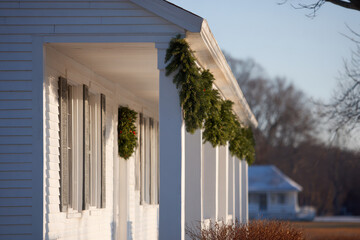 closeup view of american house beautifully adorned with garlands and wreaths on porch
