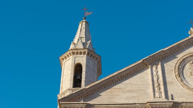 Pienza cathedral facade with bell tower in tuscany italy. The renaissance facade of the cathedral of pienza, showing the bell tower and the piccolomini papal coat of arms in the pediment