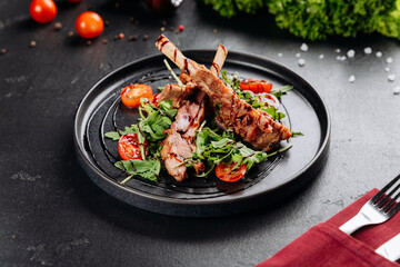Grilled ribs on arugula with cherry tomatoes and balsamic glaze, restaurant plating