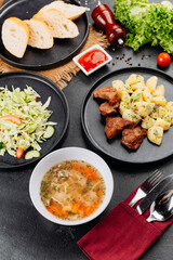 Hearty restaurant lunch: soup, fried meat with potatoes, fresh cabbage salad and bread