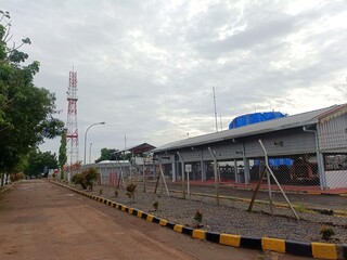 a connecting road to the oil and gas processing industrial area which is bordered by an iron wire fence