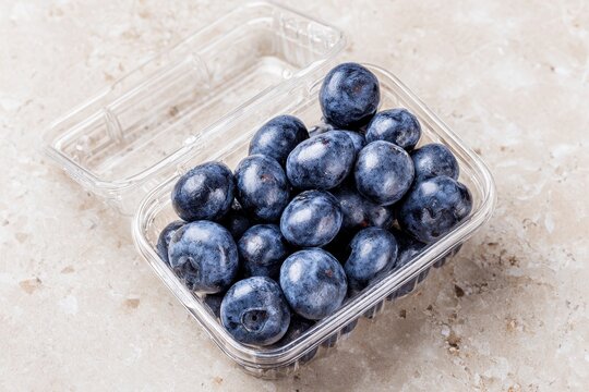 Freshly Opened Clamshell Container of Blueberries on a White Countertop with Copy Space