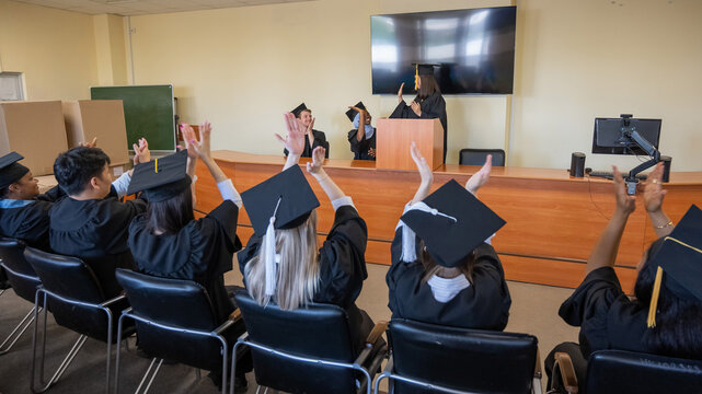 A young woman stands at the lectern and delivers a graduation speech to her classmates.  - Powered by Adobe