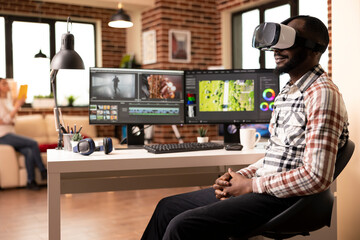 African american movie colorist using augmented reality software in adjusting color and tone of video during editing process. Black man with vr glasses reviewing edited footage in home studio.