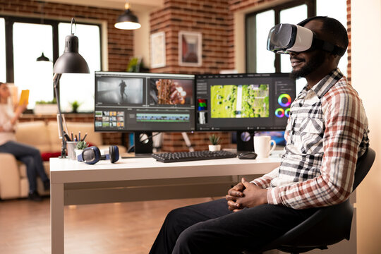 African american movie colorist using augmented reality software in adjusting color and tone of video during editing process. Black man with vr glasses reviewing edited footage in home studio.