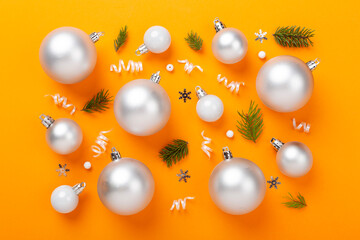 Grey Christmas balls with decor on color background, top view