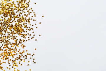 Golden star shape confetti on color background, top view
