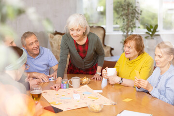 Fototapeta premium Group of senior friends at home, playing board games