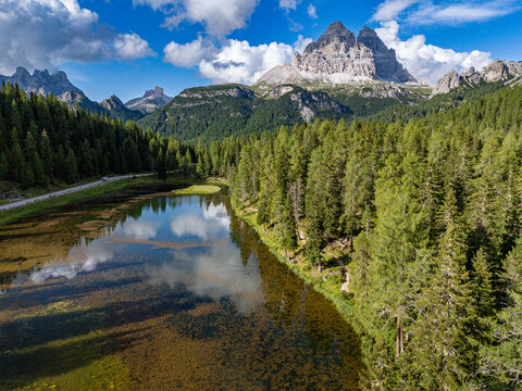 The iconic Tre Cime di Lavaredo (Drei Zinnen) mountain peaks are perfectly reflected in the calm waters of Lago d'Antorno in the Italian Dolomites.