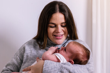 Young mother smiling while holding newborn baby