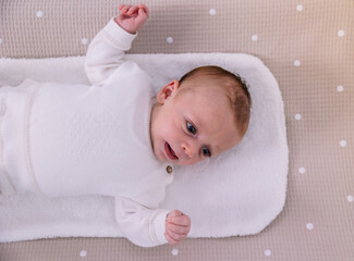 Newborn baby relaxing on changing mat at home