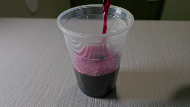 Pouring Red Wine into a Ribbed Plastic Cup
