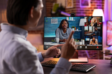 Young asian man gesturing while explaining business strategy during video conference. Remote coworkers collaborate online from different locations, discussing upcoming projects and marketing ideas.
