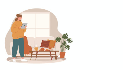 Cozy woman uses tablet in falldecorated living room Home leisure and relaxation