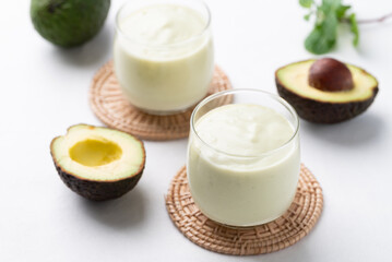 Avocado smoothie with milk in glass and avocado fruit on white background, Healthy drink