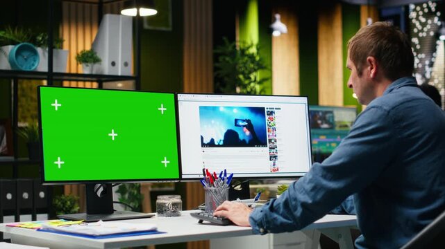 Mockup next to professional male editor checking PC reels on software in office, developing marketing strategy used in targeting viral trends and boosting online followers and exposure. Camera B.