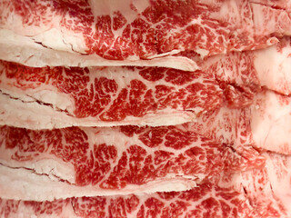 Filled frame background close up of raw thinly sliced lamb meat ready to cook