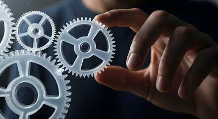 Close-up of a hand holding a gear, symbolizing teamwork and industry.