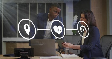 Two business colleagues reviewing tablet, woman tapping to navigate while icons animating metrics - Powered by Adobe